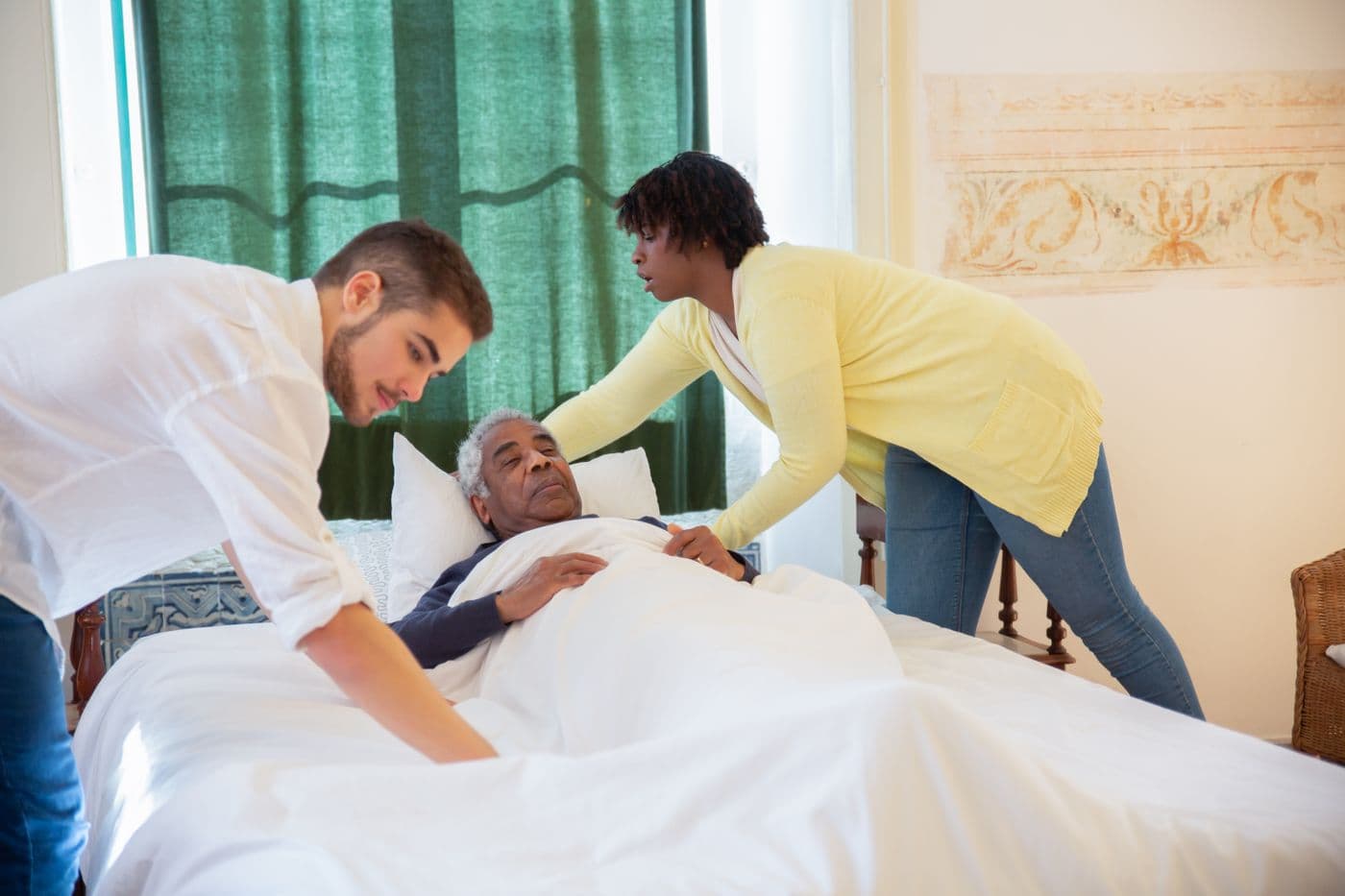 Carers supporting a client with gentle bedside care