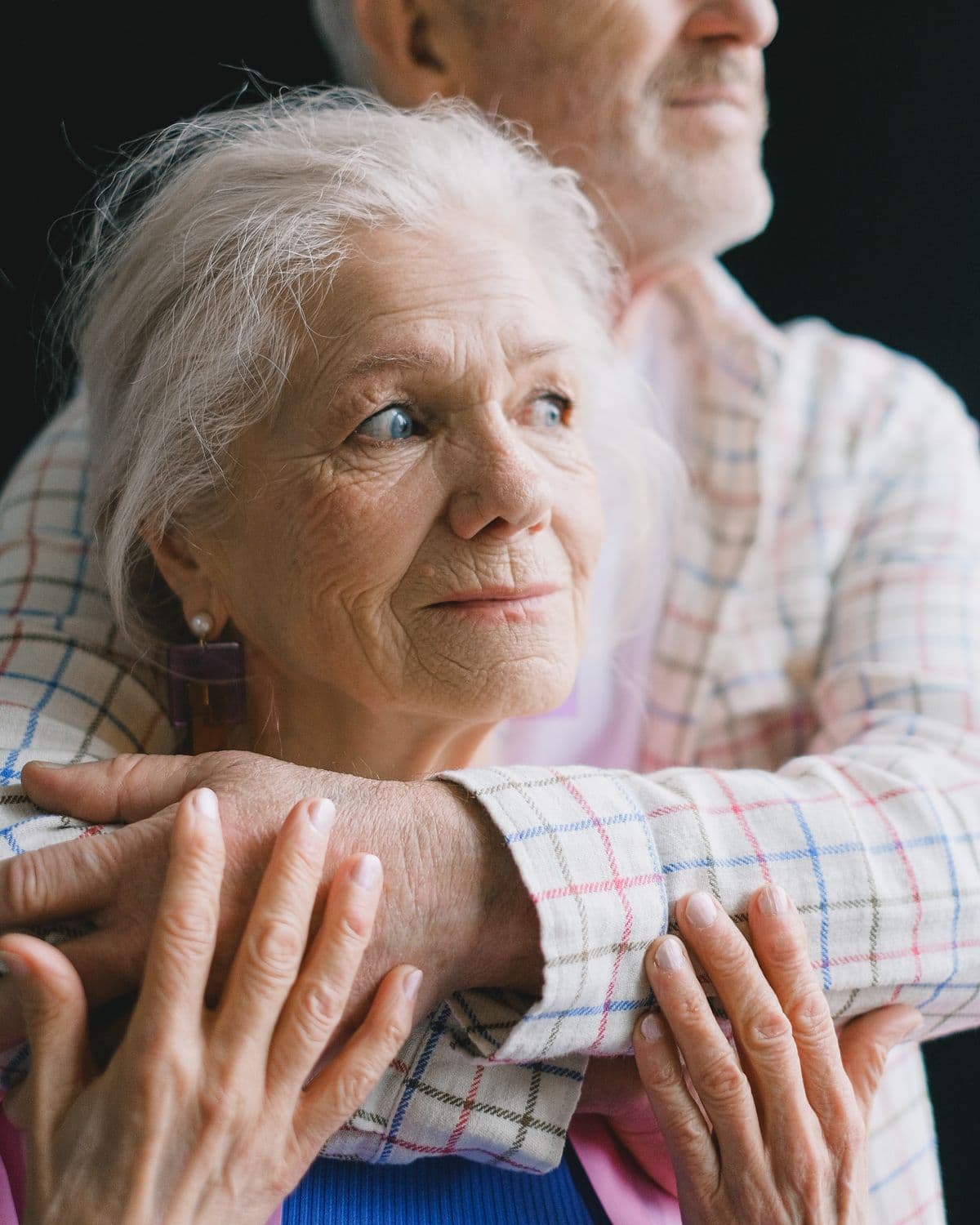 An older couple embracing tenderly at home